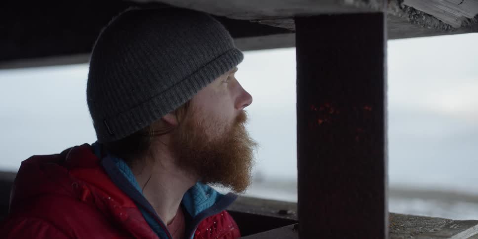 Bearded man looking out from a bunker type structure high from high above