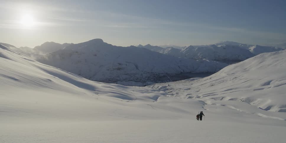 Two people hike through the snow