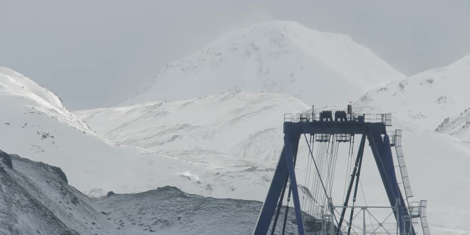 Mechanical structure standing next to snowy mountains