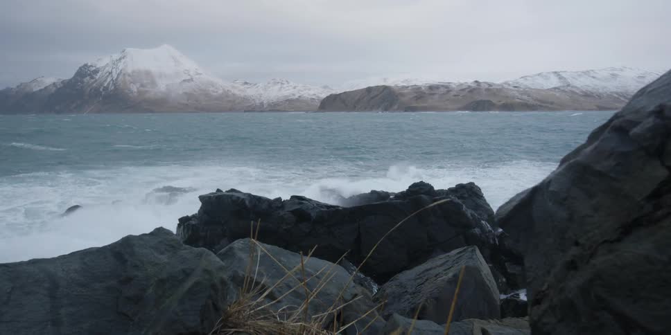 The waves splash and rise by the rocky shore