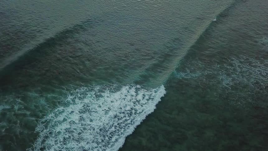 Ocean waves wash ashore at sunset
