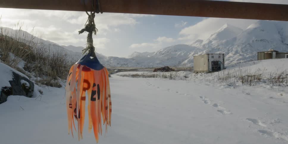 A shredded buoy on a gate