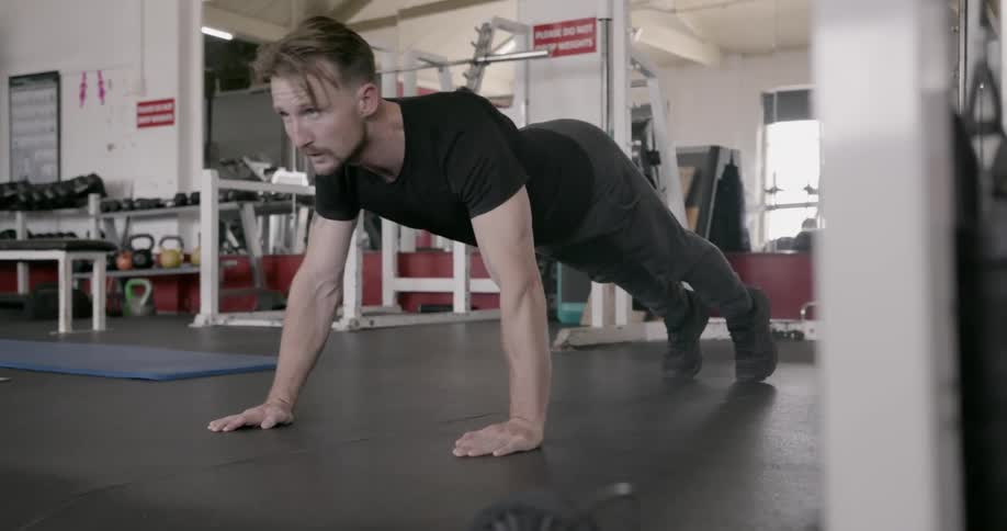 A man does push-ups in a gym