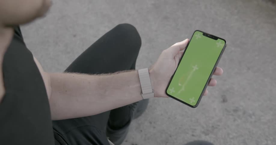 A man is using his cellphone outside during the day
