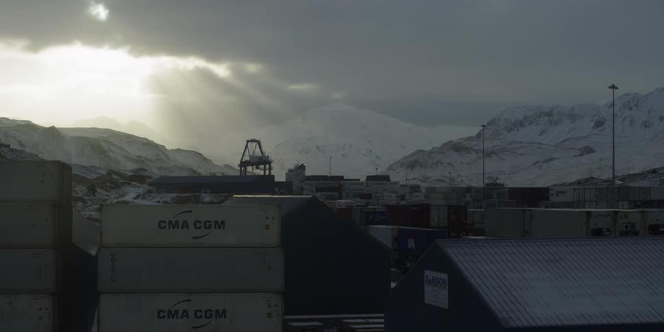 Clouds pass over a dock with stacked shipping containers