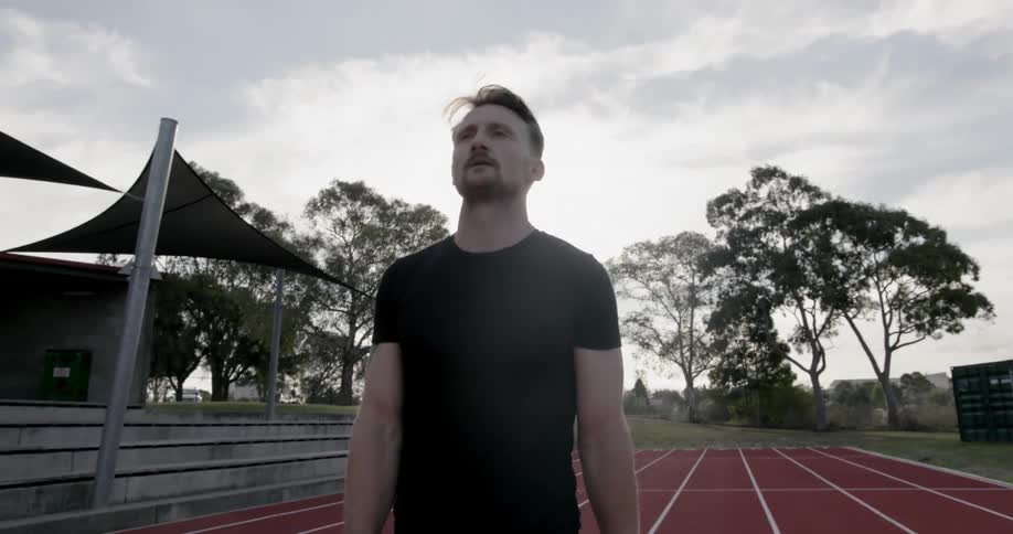 A man exhales while walking on a running track