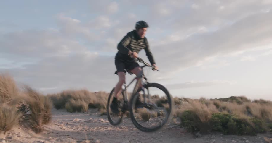 A bicyclist jumps into the air at sunset