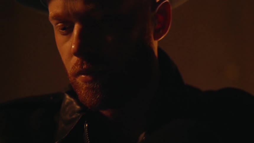 Man stands in a dark area with light reflecting his face