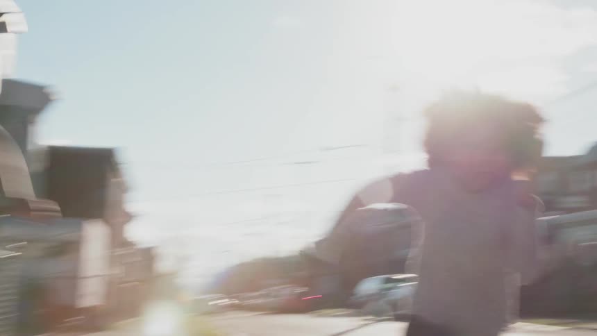 A woman and a girl are racing down a street in an urban neighborhood during the day