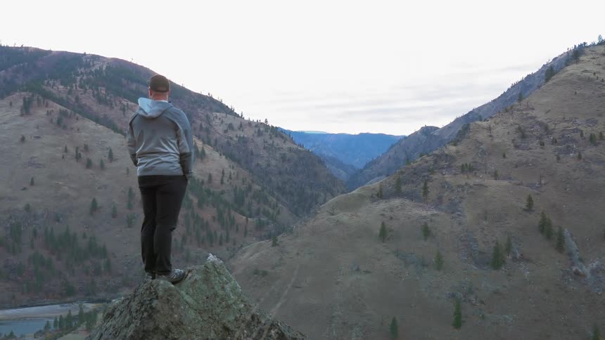 A hiker overlooks a mountain valley