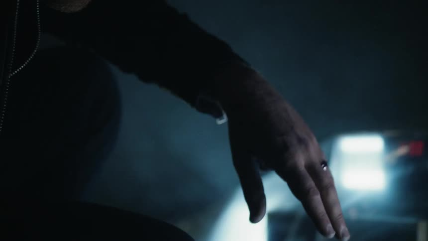 Man reaches out to a tv on the floor of a dark room