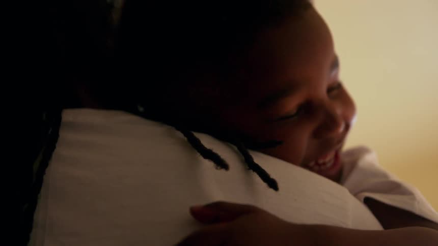 A child smiles in a parent's arms
