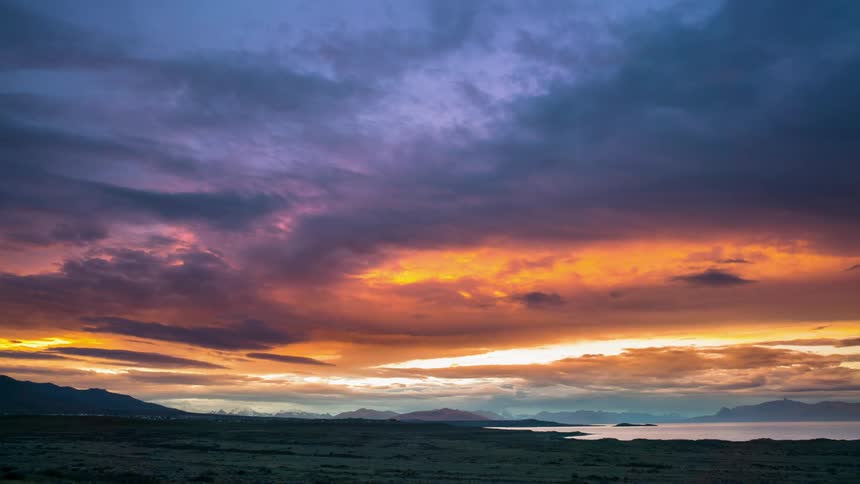 The clouds roll over the shore at sunrise