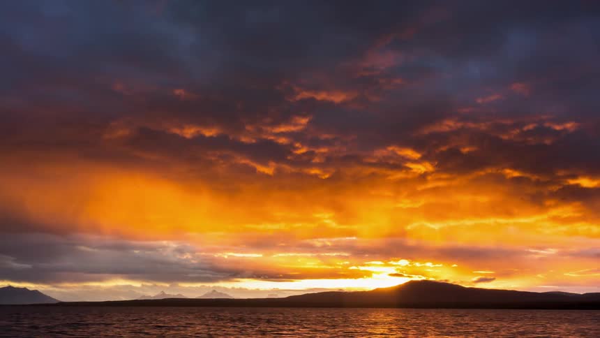 The water rushes past the shore at sunset