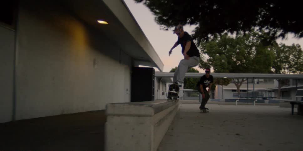 They ride their skateboards around the lot on a cloudy day