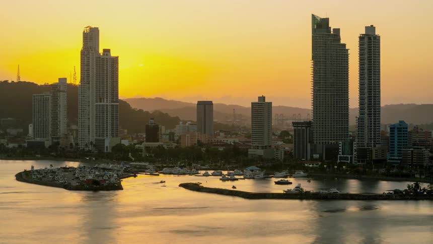 The sun is setting behind the tall buildings
