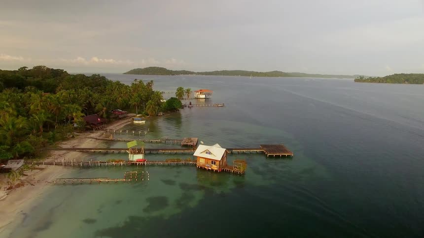 Docks and floating cabins over clear blue ocean water in Bocas del Toro