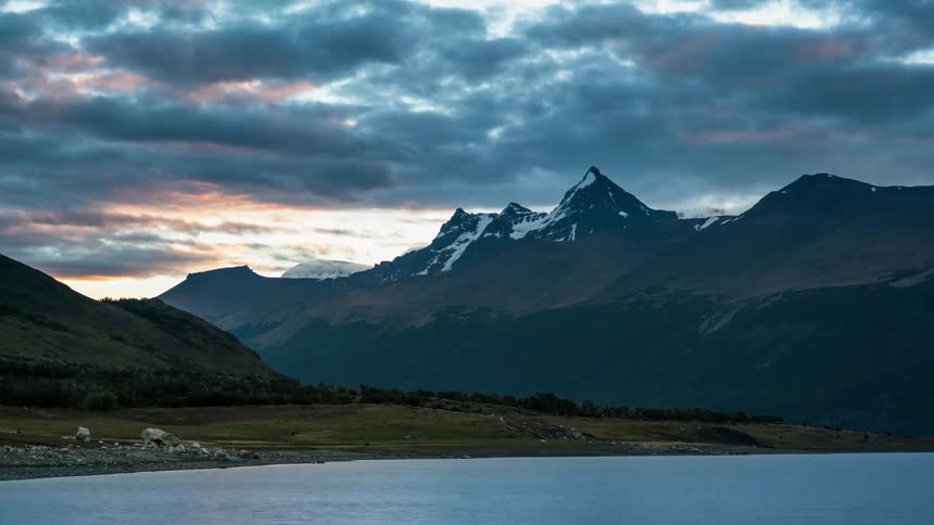 Clouds pass over mountain peaks and water