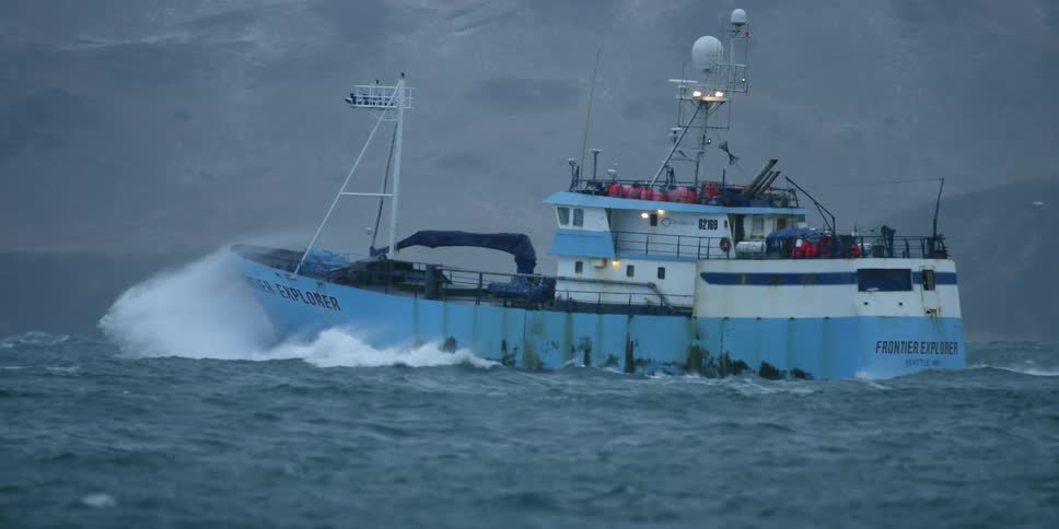 A fishing ship crashes through waves