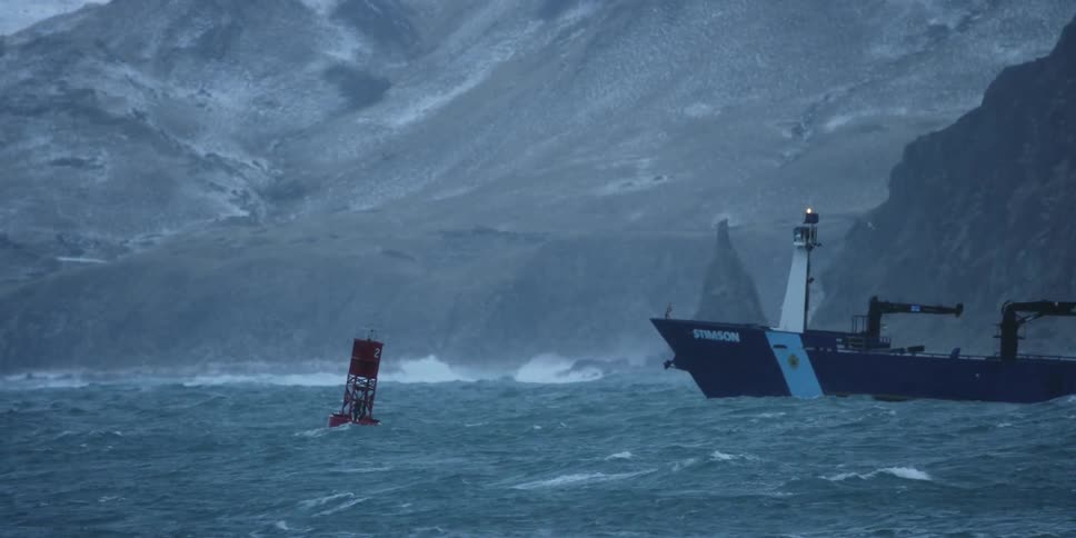 A ship crashes through waves on a stormy day
