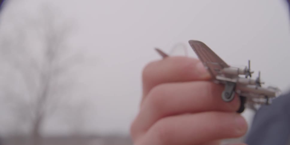 Boy flying a toy airplane in front of him