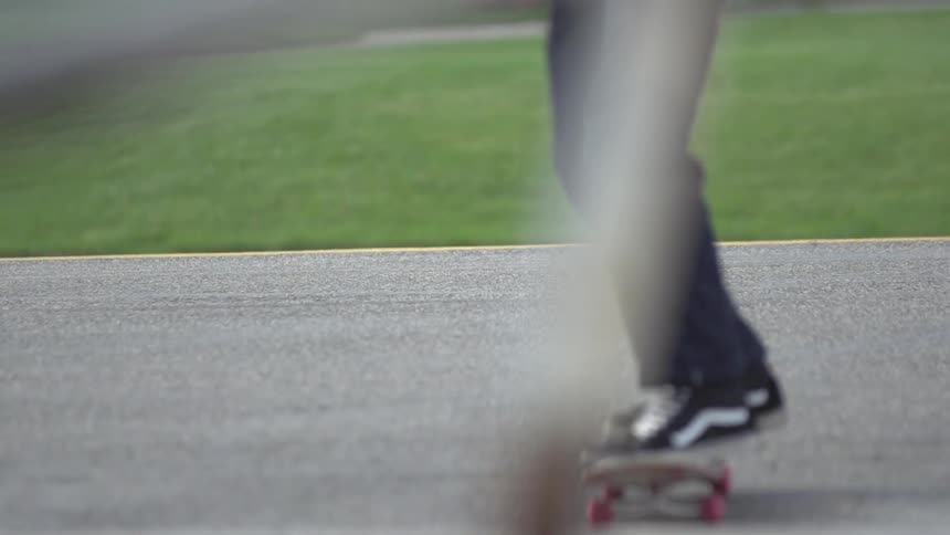 Man rides a skateboard on a up a small hill