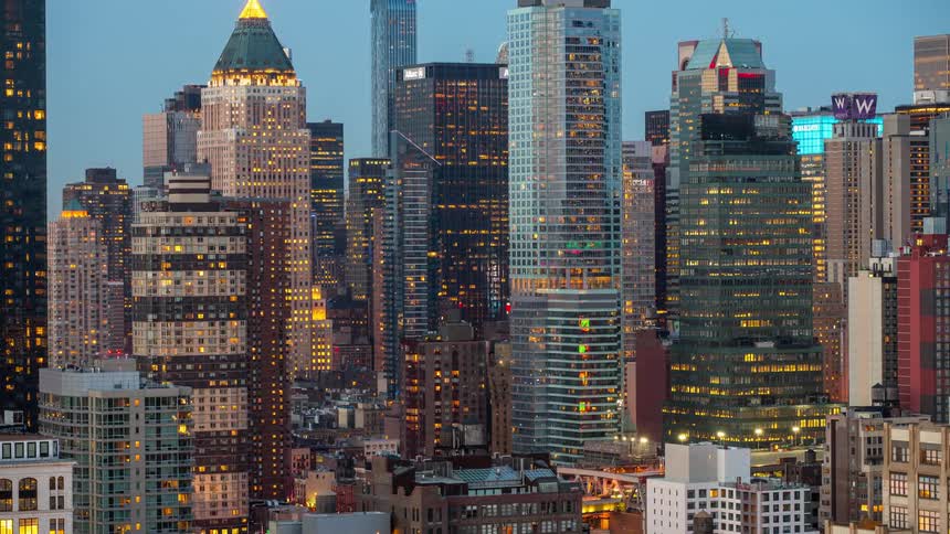 Tall skyscrapers lit up against nightfall