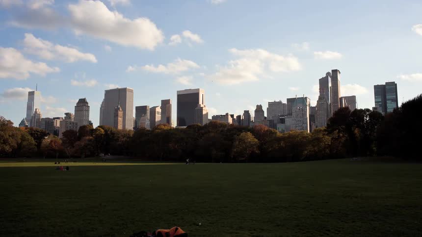 People walk and enjoy a city park on a sunny day
