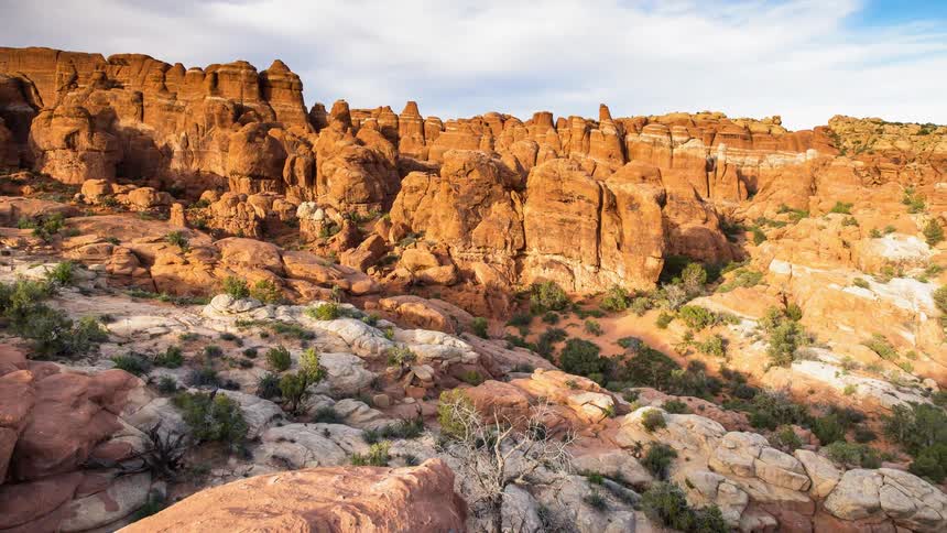 Clouds float over rocky cliffs in the desert