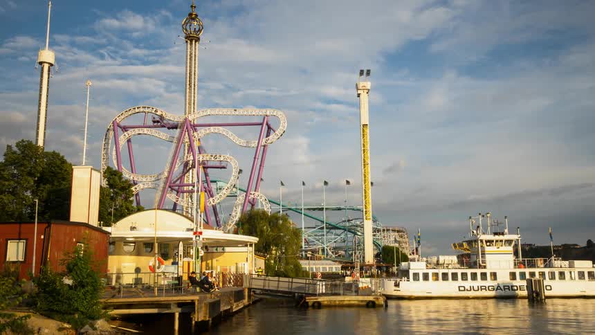 A ferry lets people off at an amusement park on the pier