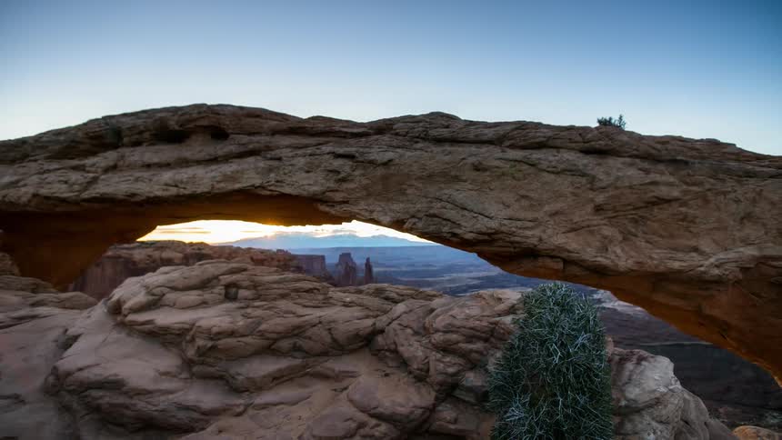 Water flows under rock formations at sunset