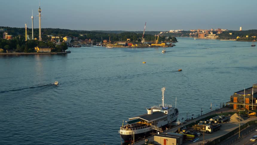 Boats float on a river at sunset