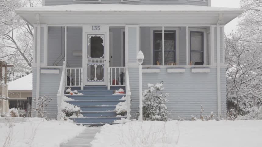 A man shovels a driveway as the snow falls