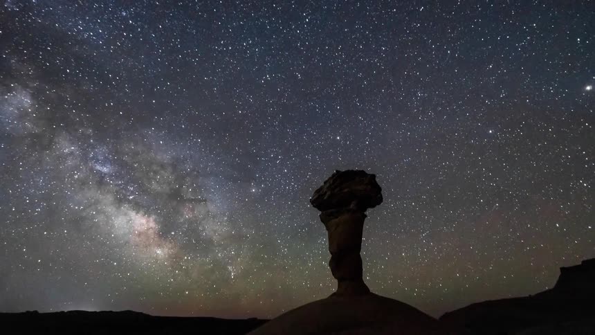 The stars light up the sky above a rock formation