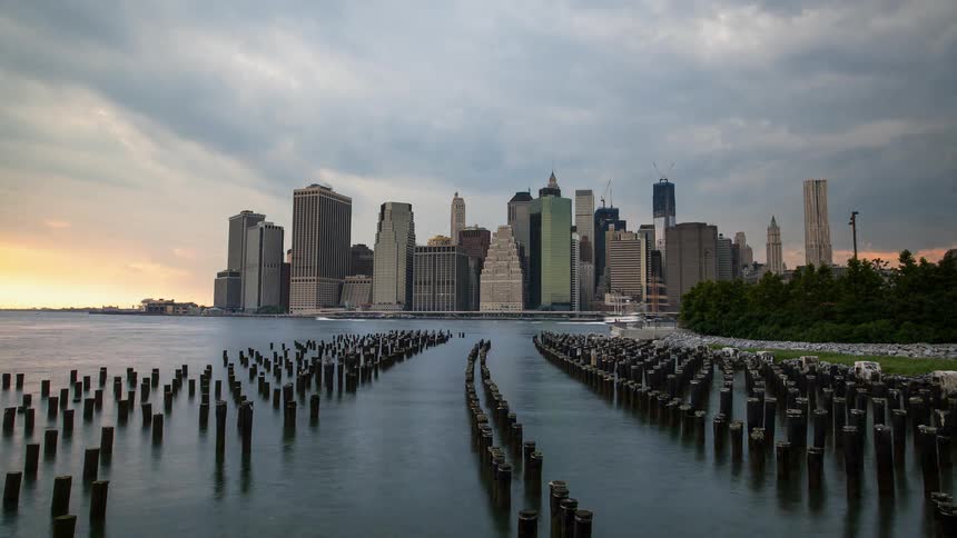 Boats and ships travel in a city harbor