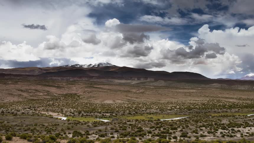 Clouds float over a snowy mountain peak