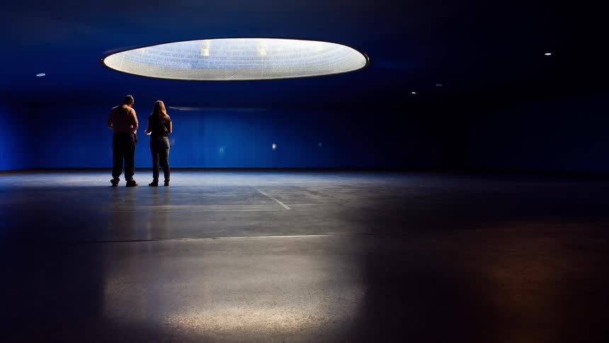 People walk in a room with a hole in the ceiling