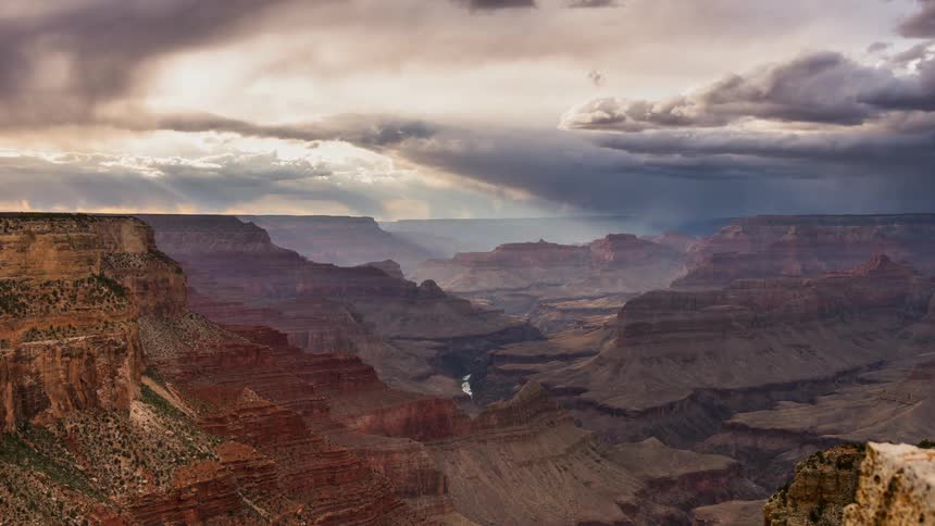 Clouds pass above a large canyon