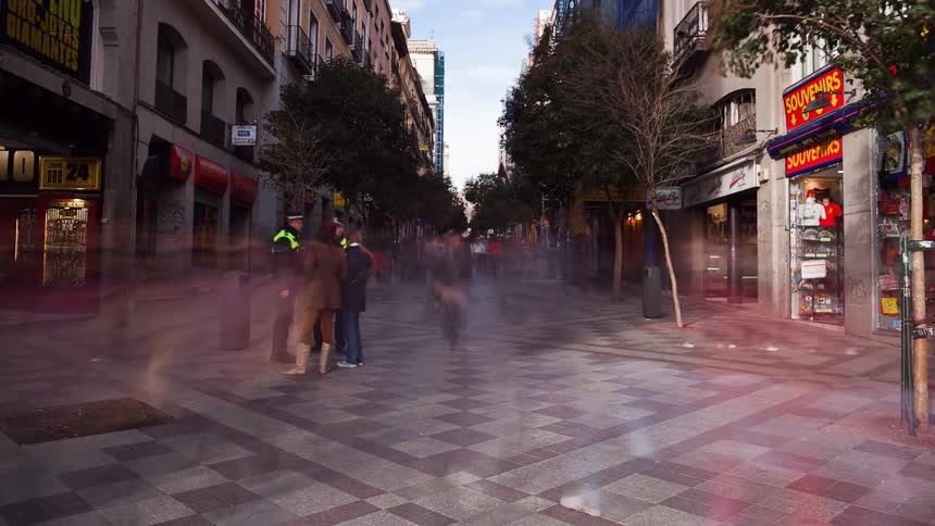 Pedestrians walk on a city sidewalk