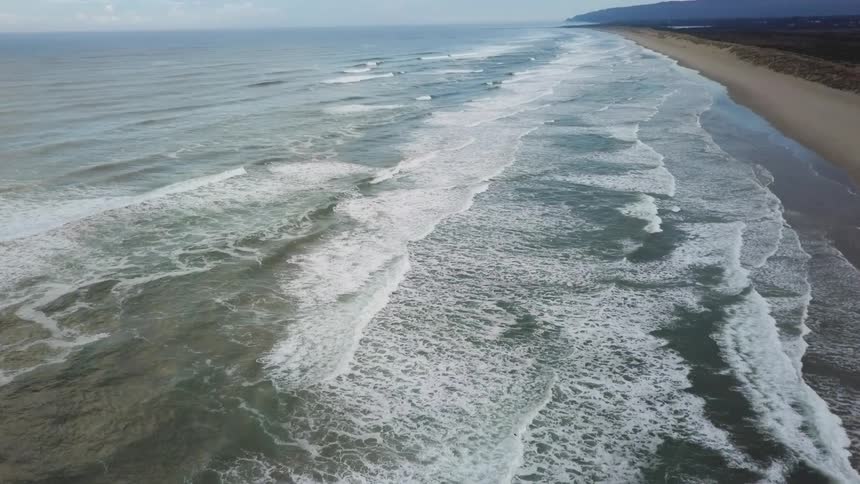 Ocean waves rolling to a sandy shore