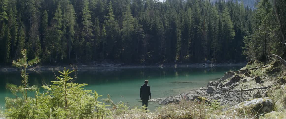 A man stands on a rock in a lake