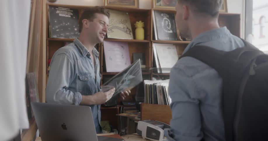 Man buys a vinyl record in a record shop