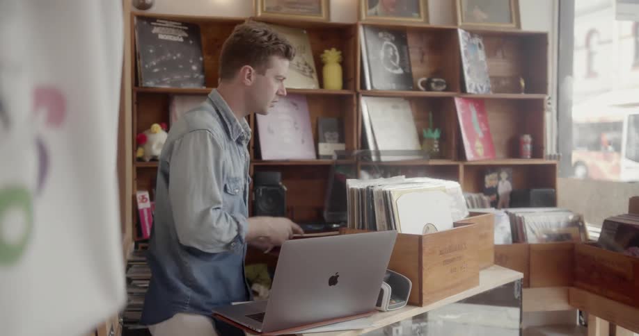 A man is working in a record store during the day