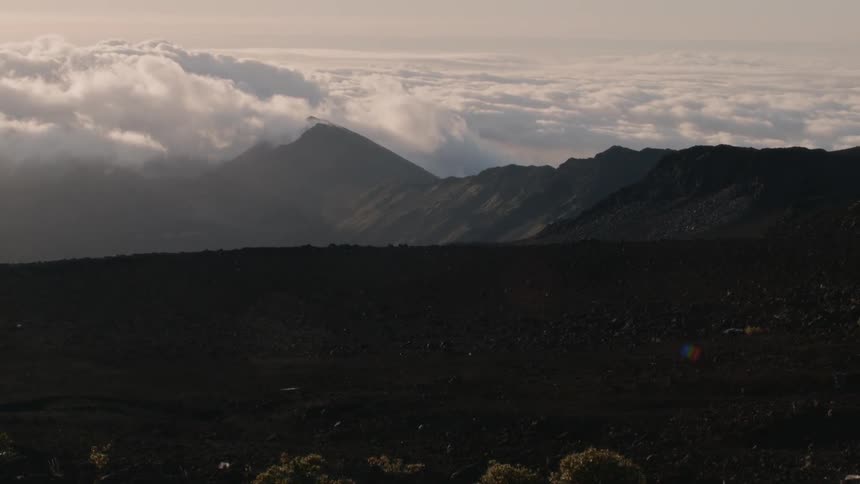 Clouds float over a mountain range at sunset