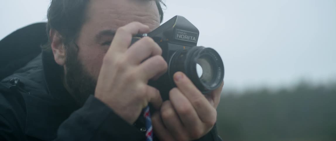A man is outside taking photographs