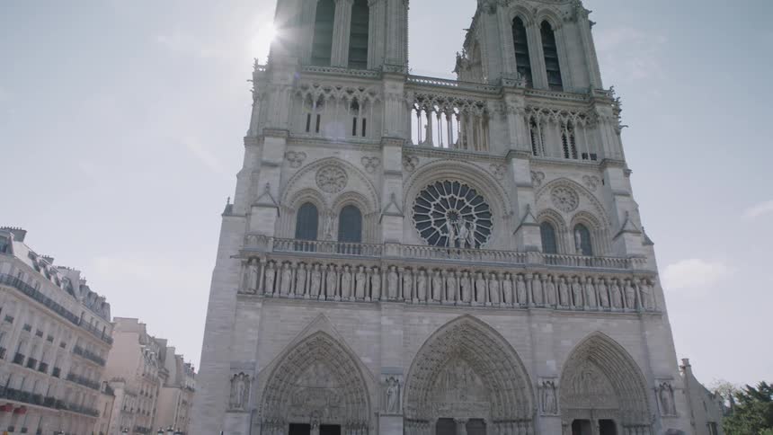 Tourists walk in front of a stone cathedral