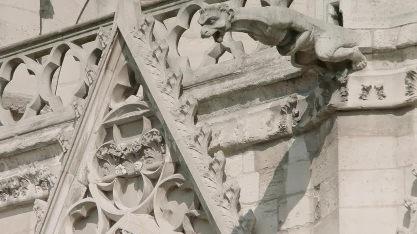 A gargoyle statue sits on a stone building