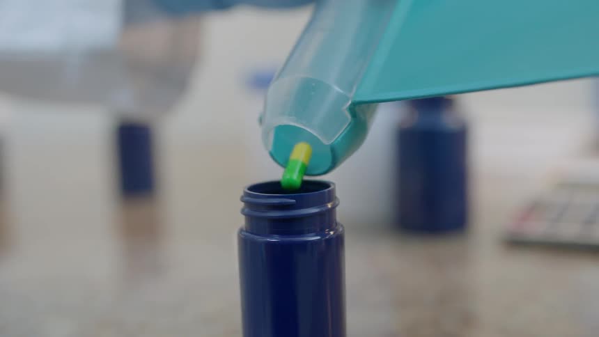 Pills are dispensed into a pill bottle