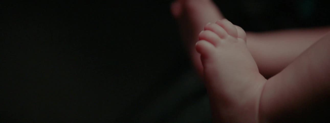 Infants feet showing in a dark area
