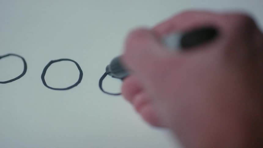 A person marks circles on a whiteboard